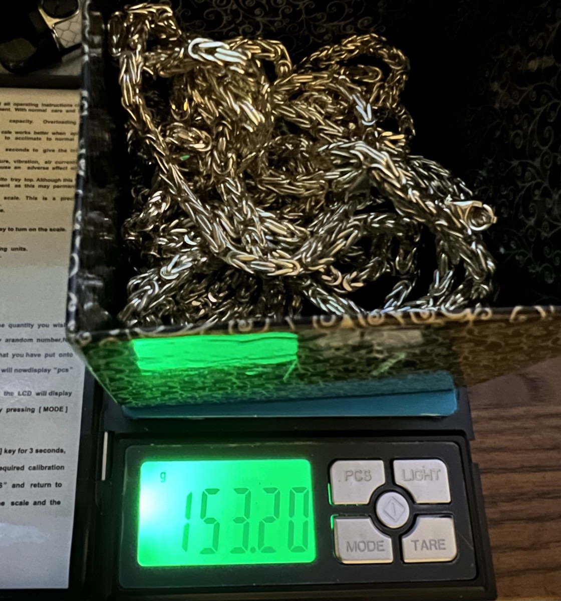 Gold chain weighed on a digital scale, 153.20 grams